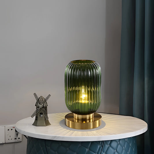 A luminescent crystal table lamp on a metal stand, placed on a desk in a room.