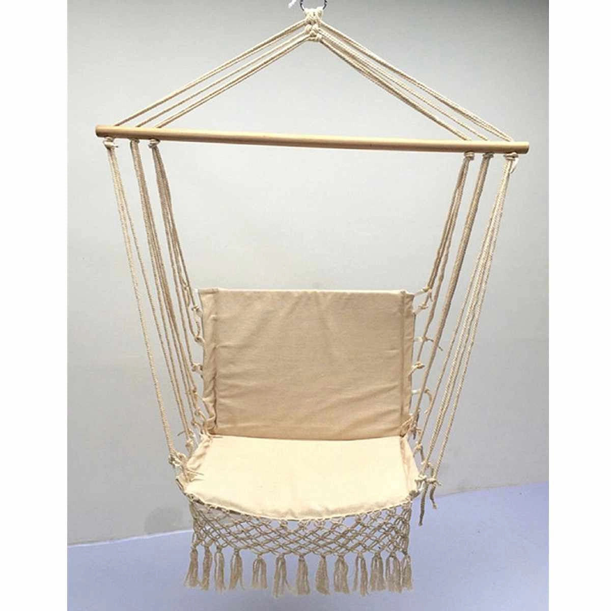 Macramé hammock swing hanging in a garden with wooden supports and shaded area.