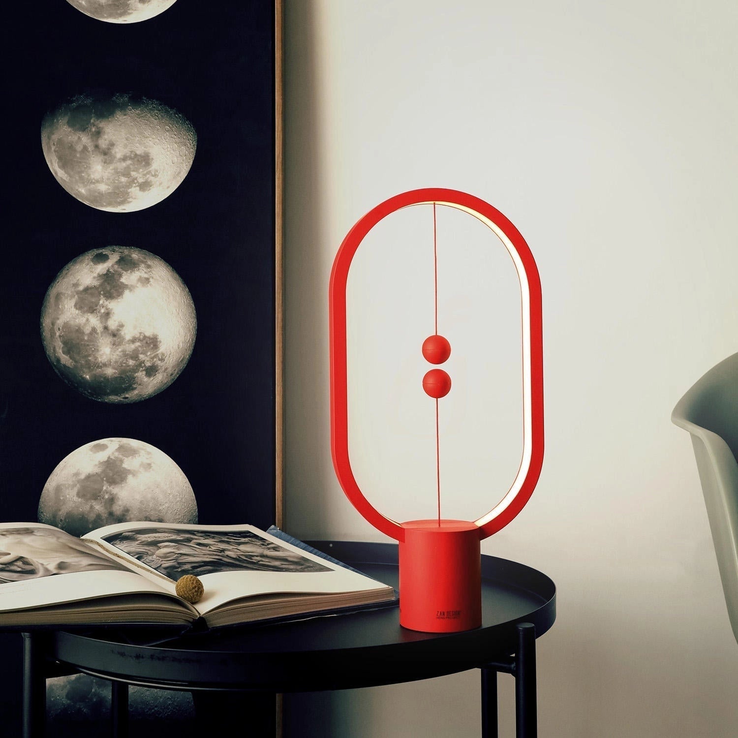 Magnetic Balance Table Lamp with LED Lighting, featuring a rectangular wooden base and a unique floating moon-shaped light, placed on a modern table in an interior setting.