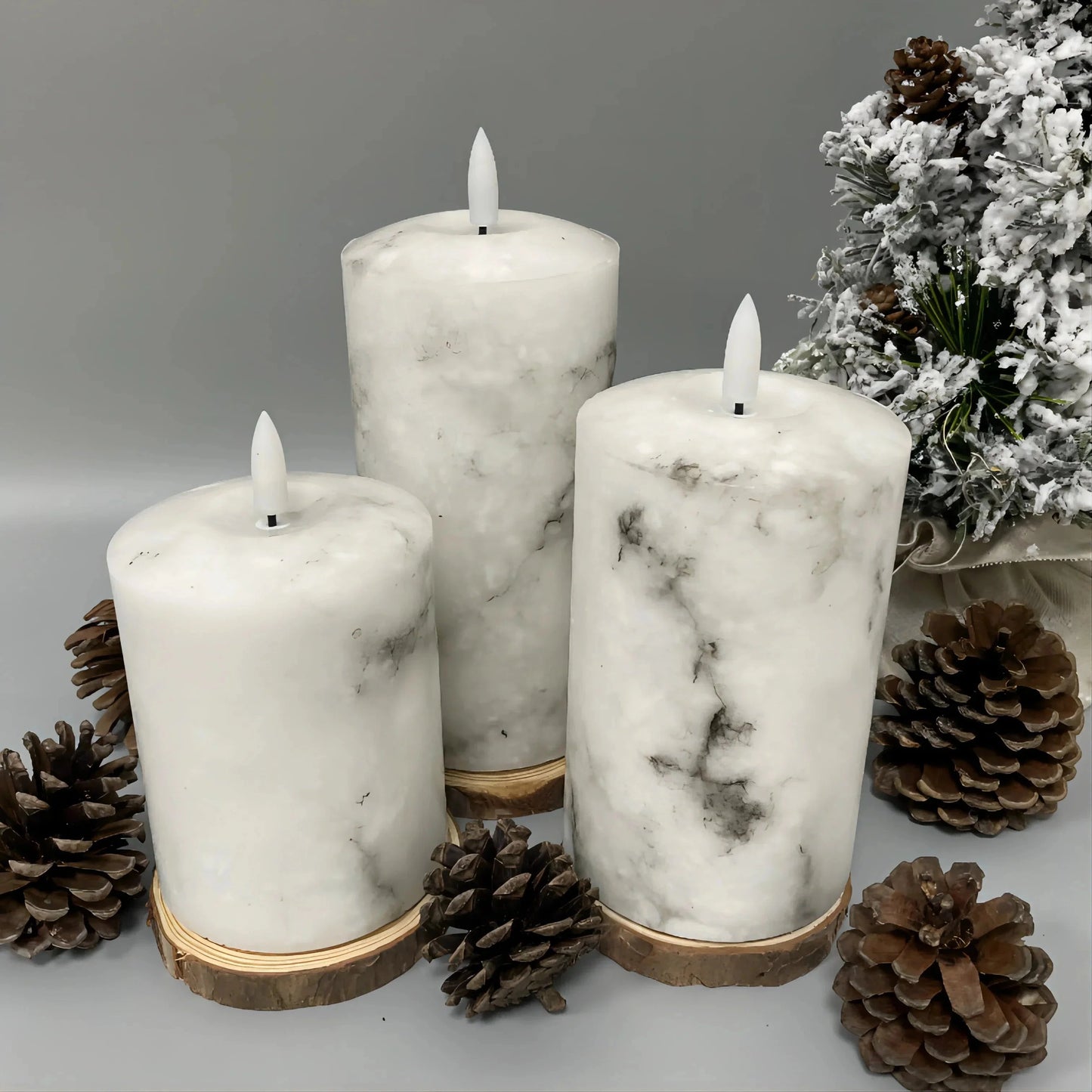 A trio of white marble LED flameless candles in cylindrical shapes, displayed without candle holders, resembling natural wax candles.