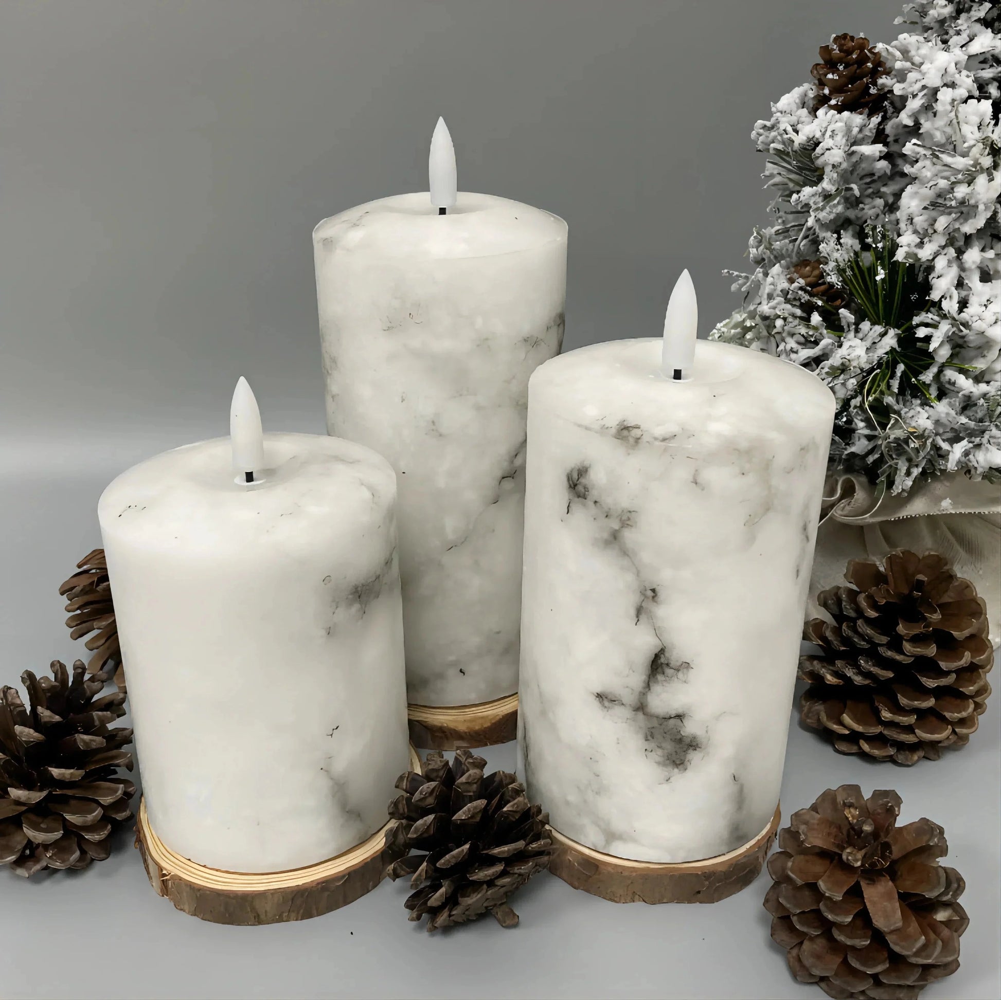 A trio of white marble LED flameless candles in cylindrical shapes, displayed without candle holders, resembling natural wax candles.