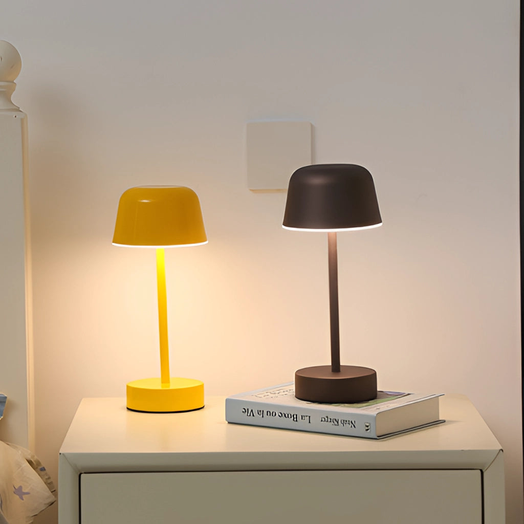 Modern grey metal table lamp with adjustable brightness, placed on a wooden surface, illuminating a stylish interior space.