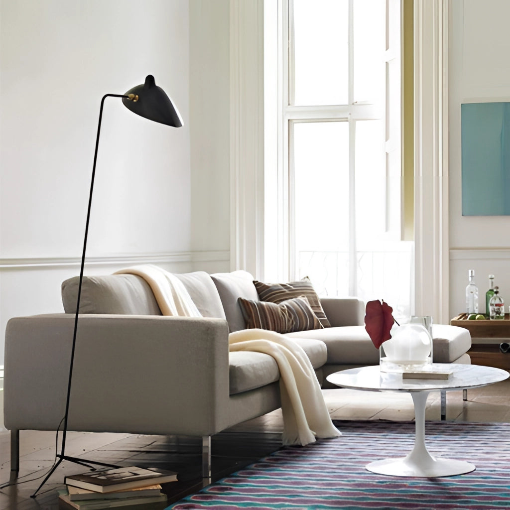 Midcentury floor lamp with tilting heads in a modern bedroom interior featuring a white couch, wooden furniture, and a large window.