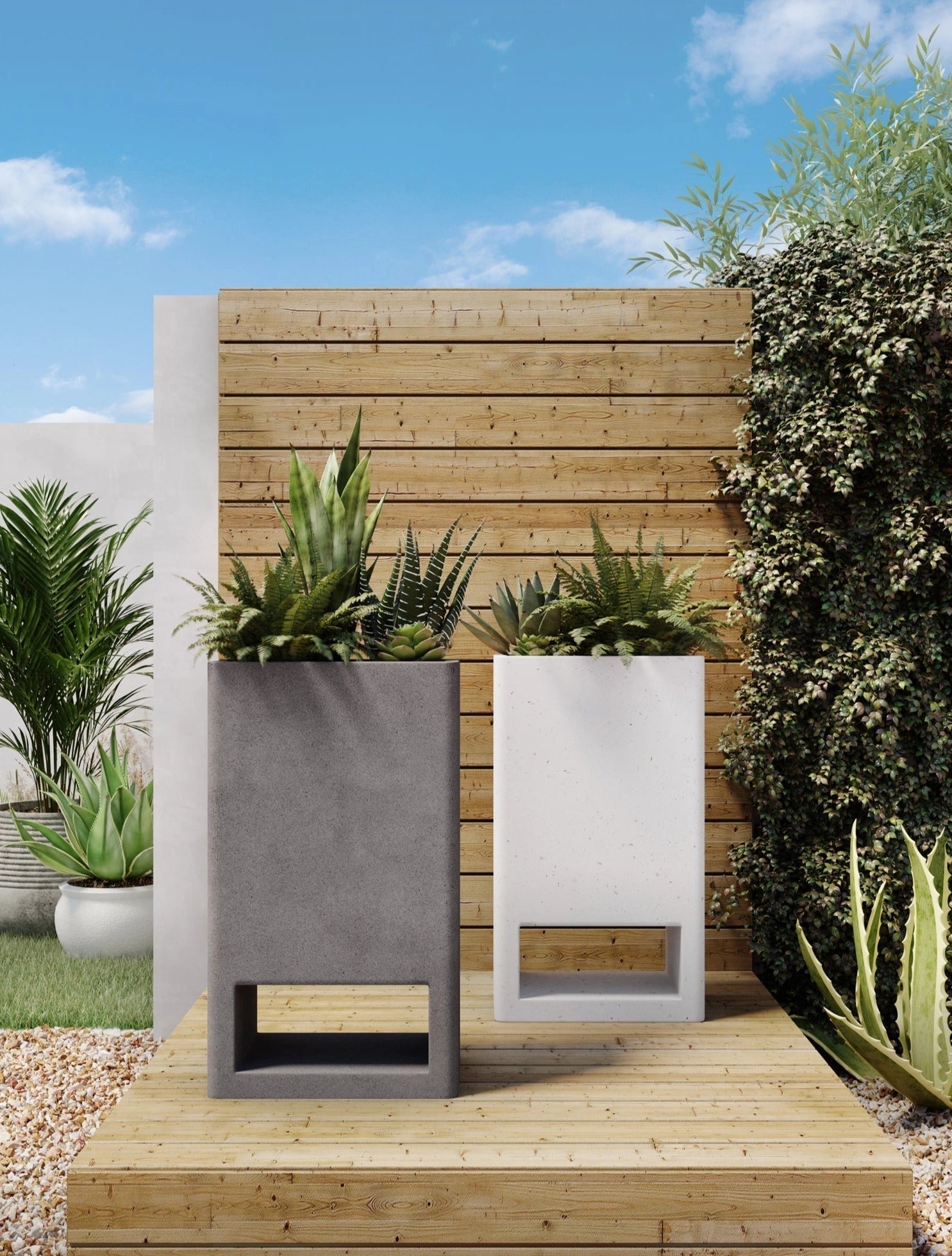 Ivory terrazzo garden planter with a green plant, placed outdoors near a wooden wall and grassy area under a partly cloudy sky.