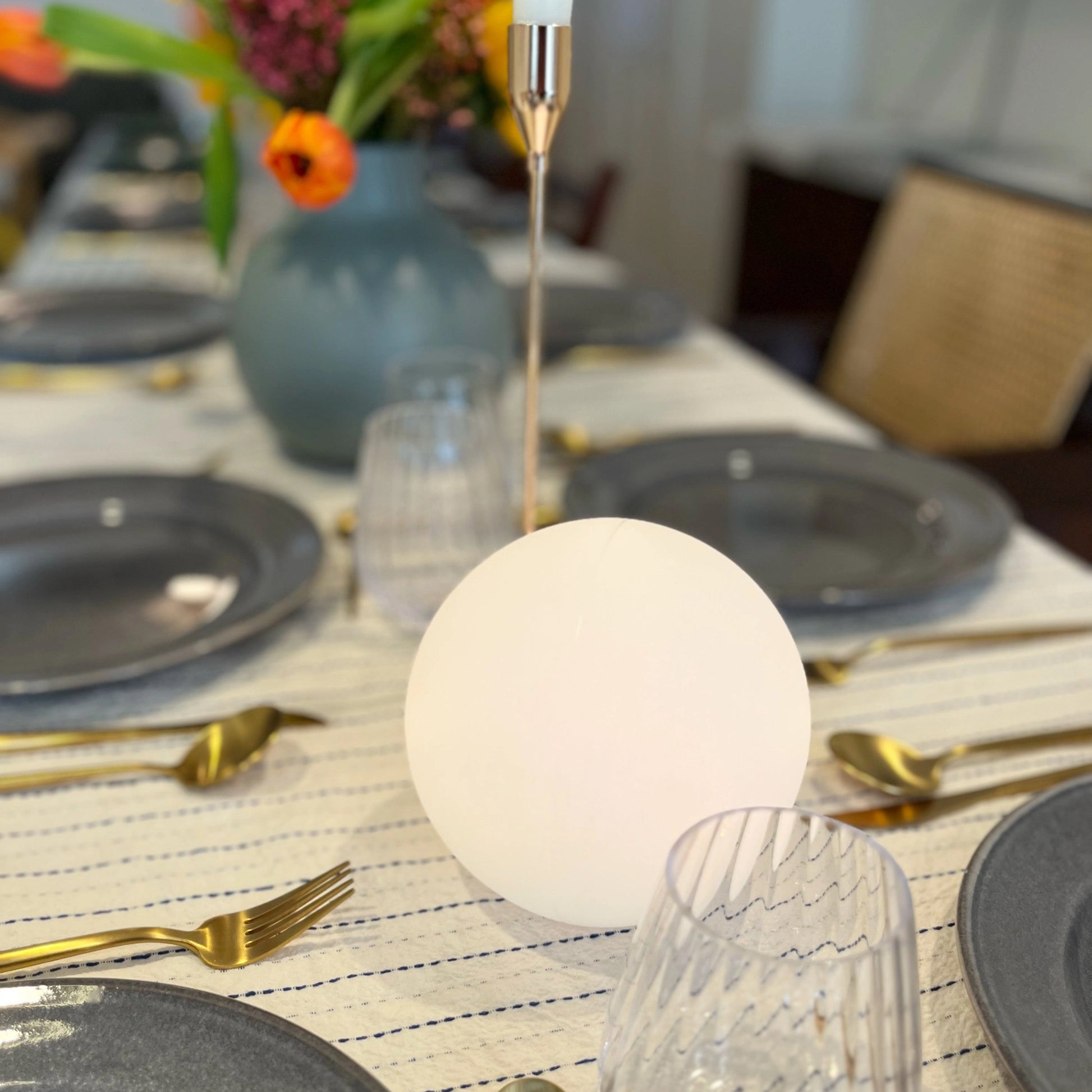 Moon Cordless LED Table Lamp with Color Control on a table alongside tableware and a flowerpot.