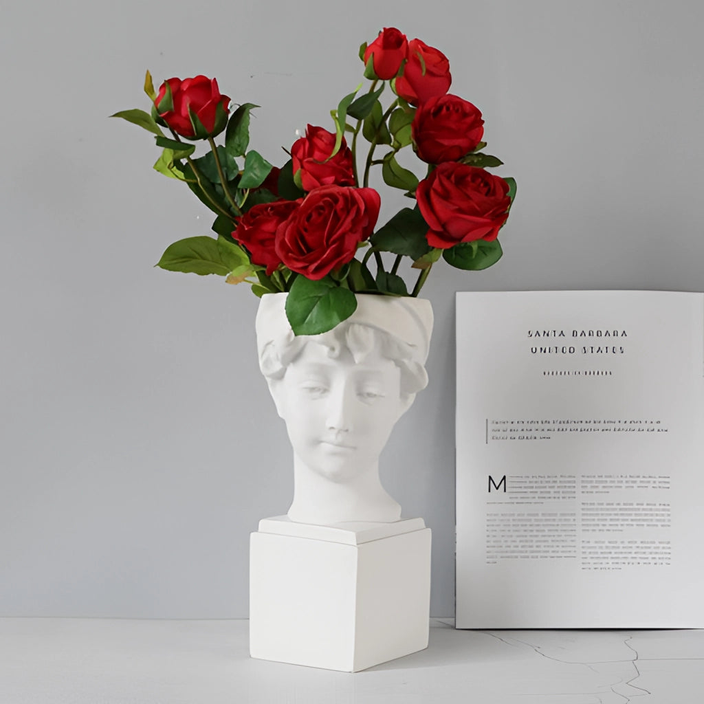 Neoclassical Greek head resin vase with blooming roses and greenery.