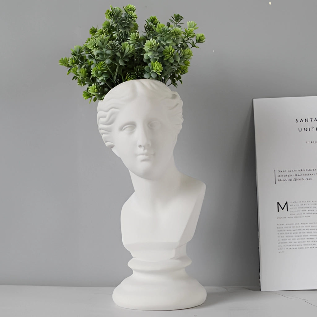 Neoclassical Greek head resin vase with a plant growing out of the top, resembling hair; detailed sculpture and art piece.