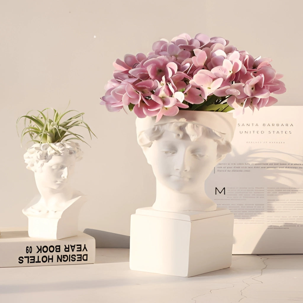 Neoclassical Greek head resin vase filled with flowers and houseplants, showcasing creative flower arranging in a white flowerpot.
