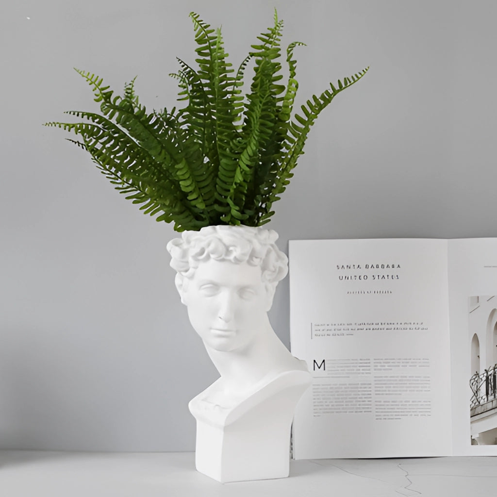 Neoclassical Greek head resin vase with intricate sculpture design, featuring a lush terrestrial plant.