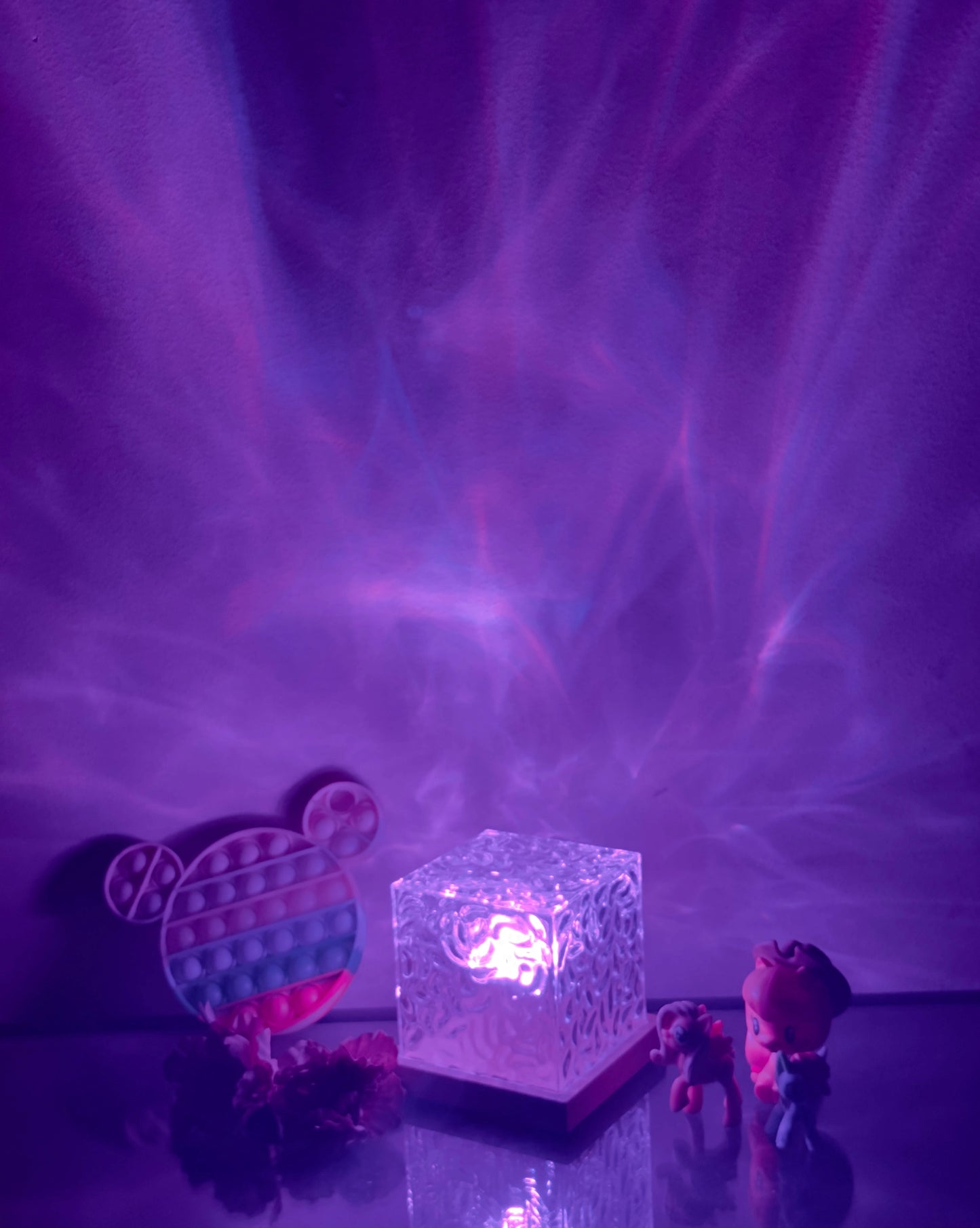 Northern Lights Inspired Cube Lamp illuminated with a blend of purple, violet, pink, and magenta hues against a cloud-like sky pattern.