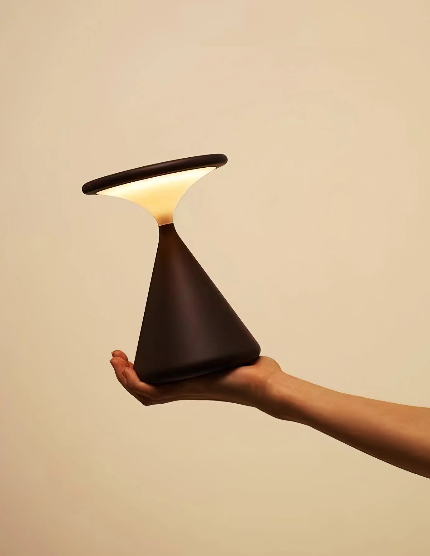 Outdoor cordless lamp for portable ambiance, Selene, displayed on a wooden table, showcasing its elegant design and versatility.