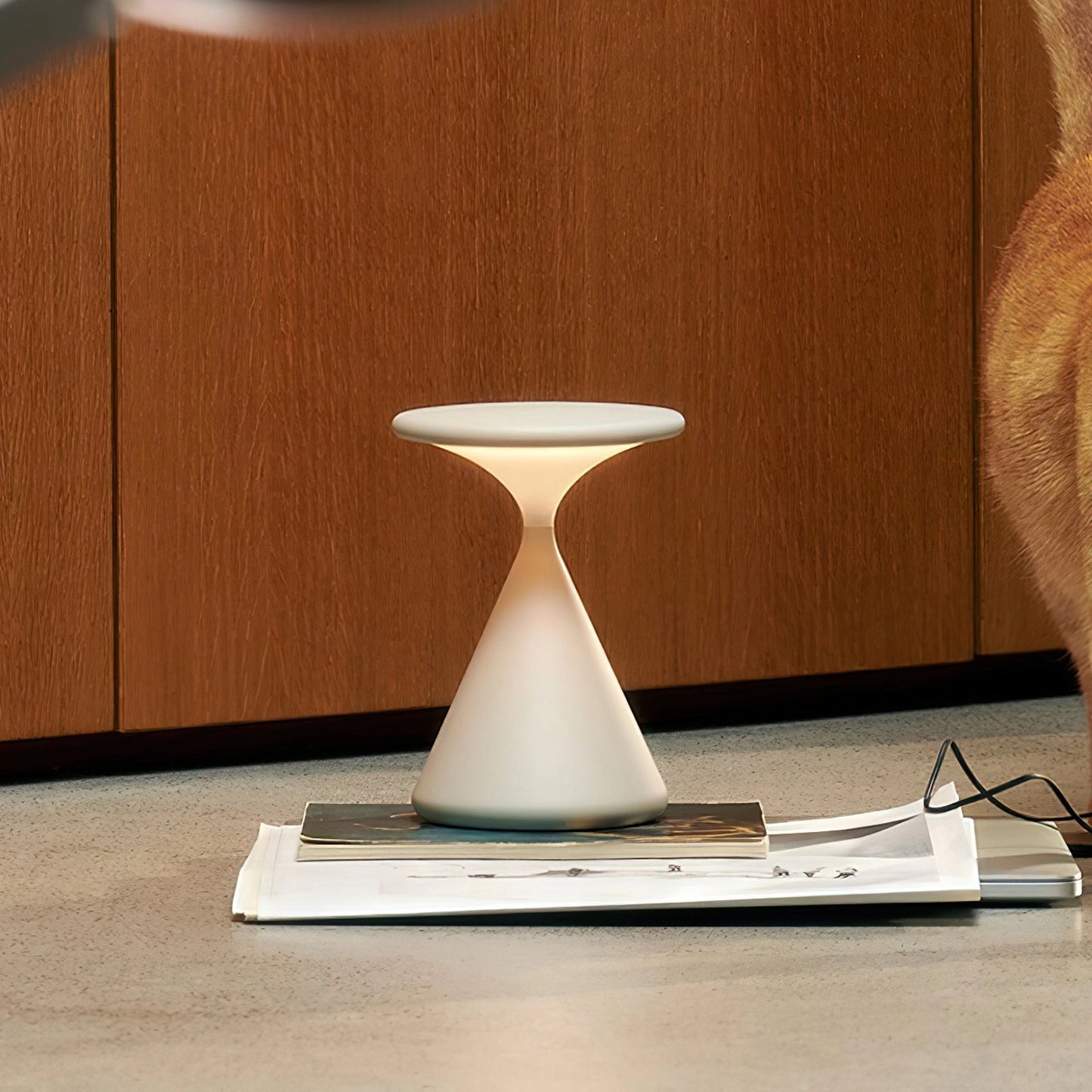 Outdoor cordless lamp on a wooden table, creating a versatile and elegant ambiance, with drinkware and hardwood flooring in the background.