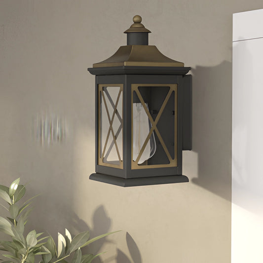 Vintage bronze candle wall sconce mounted on an outdoor wooden wall near a window with surrounding plants and lantern design.