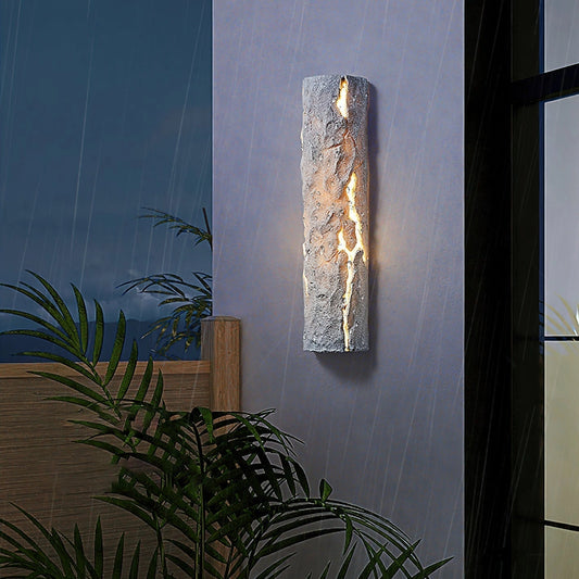 Outdoor wall light with IP65 waterproof rating, premium resin faux rock finish, mounted on a wall with plants in the background.
