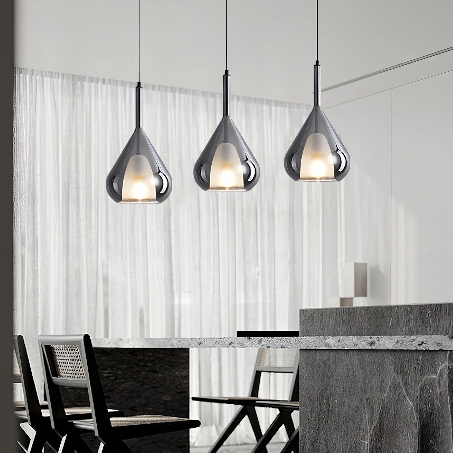 Nordic style pendant lamp with a clear raindrop design and starlight effect, hanging over a wooden table with grey chairs, featuring a monochrome interior design setting.
