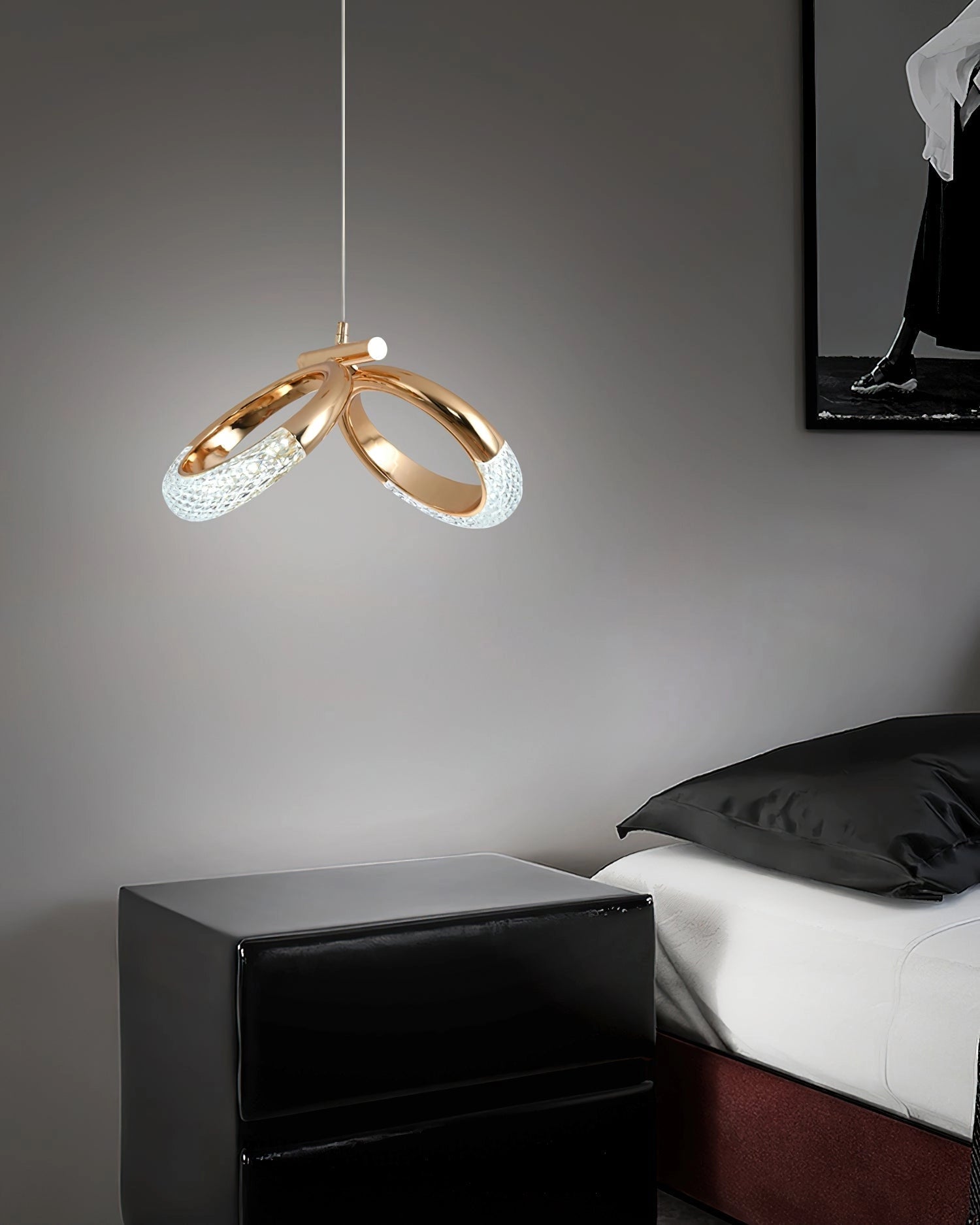 Modern pendant lamp Dante chandelier in white and black, illuminating a comfortable living room with a grey couch and wooden accents.