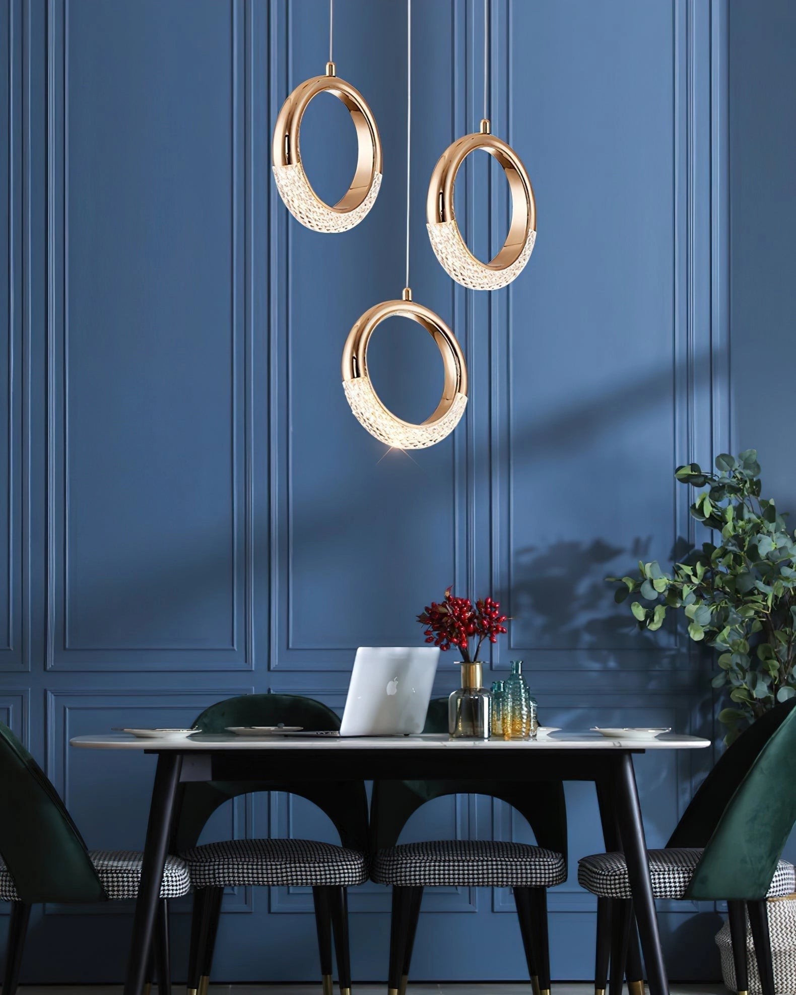 A modern pendant lamp chandelier hanging above a table with surrounding furniture, plants, and a window in a well-lit interior design setting.