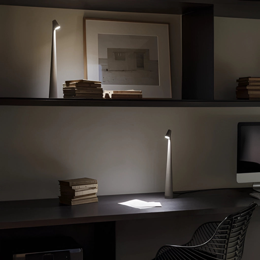 Portable rechargeable LED table lamp with aluminum construction, featuring three light intensities, placed on a wooden shelf in a modern interior design setting.