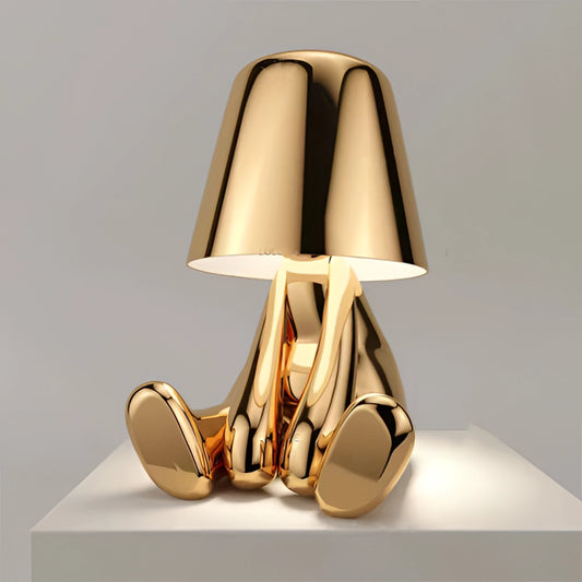 Modern gold thinker statue LED table lamp with a relaxing gold finish, featuring a wood base and a stylish lampshade.