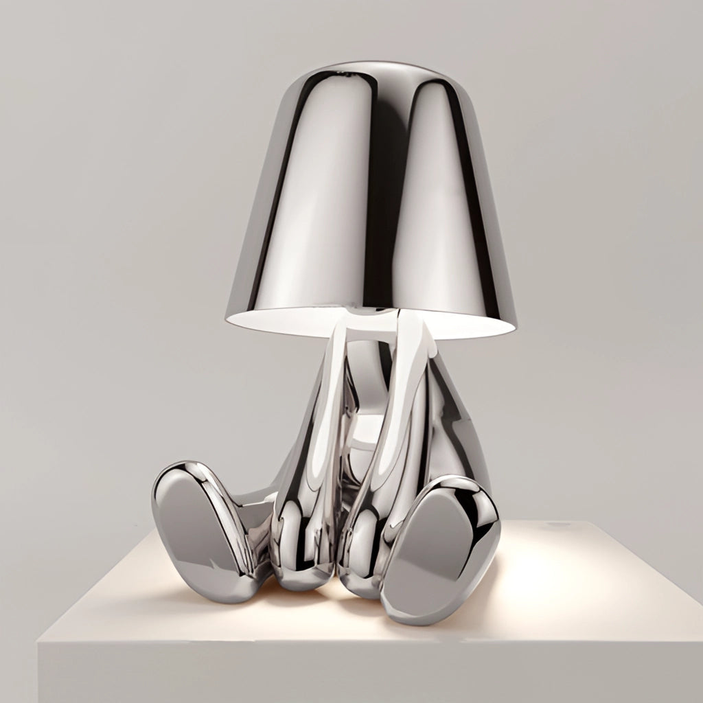 A modern LED table lamp featuring a silver statue of a thinker in a relaxing pose.