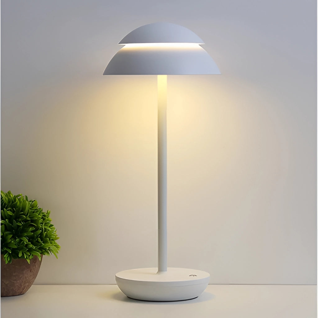 Scandinavian design table lamp in white with a wooden base, placed on a table beside a potted plant.