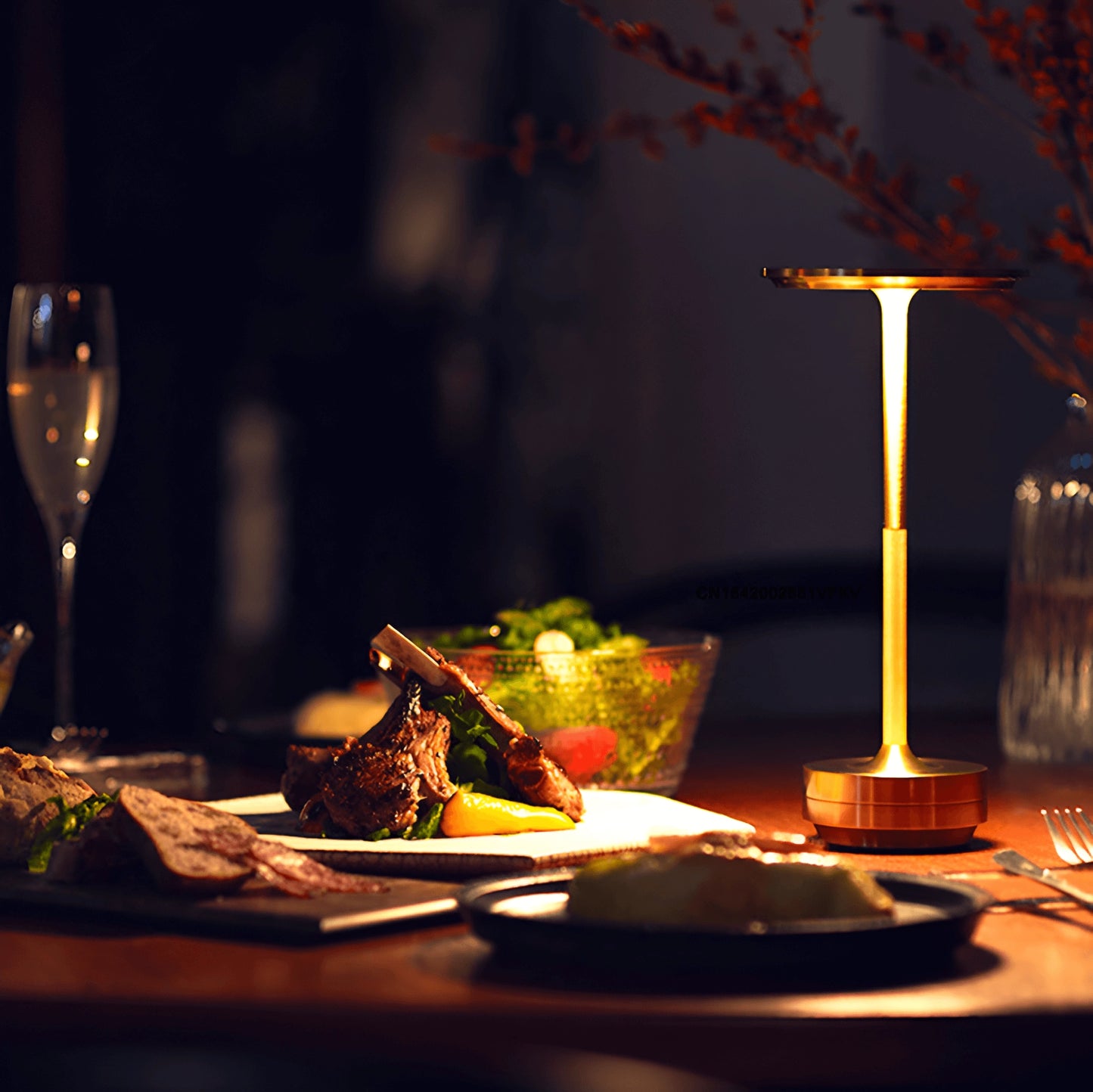 Rechargeable LED table lamp providing cordless mood lighting, placed on a dining table set with tableware including plates, stemware, and a candle, creating an elegant ambiance.