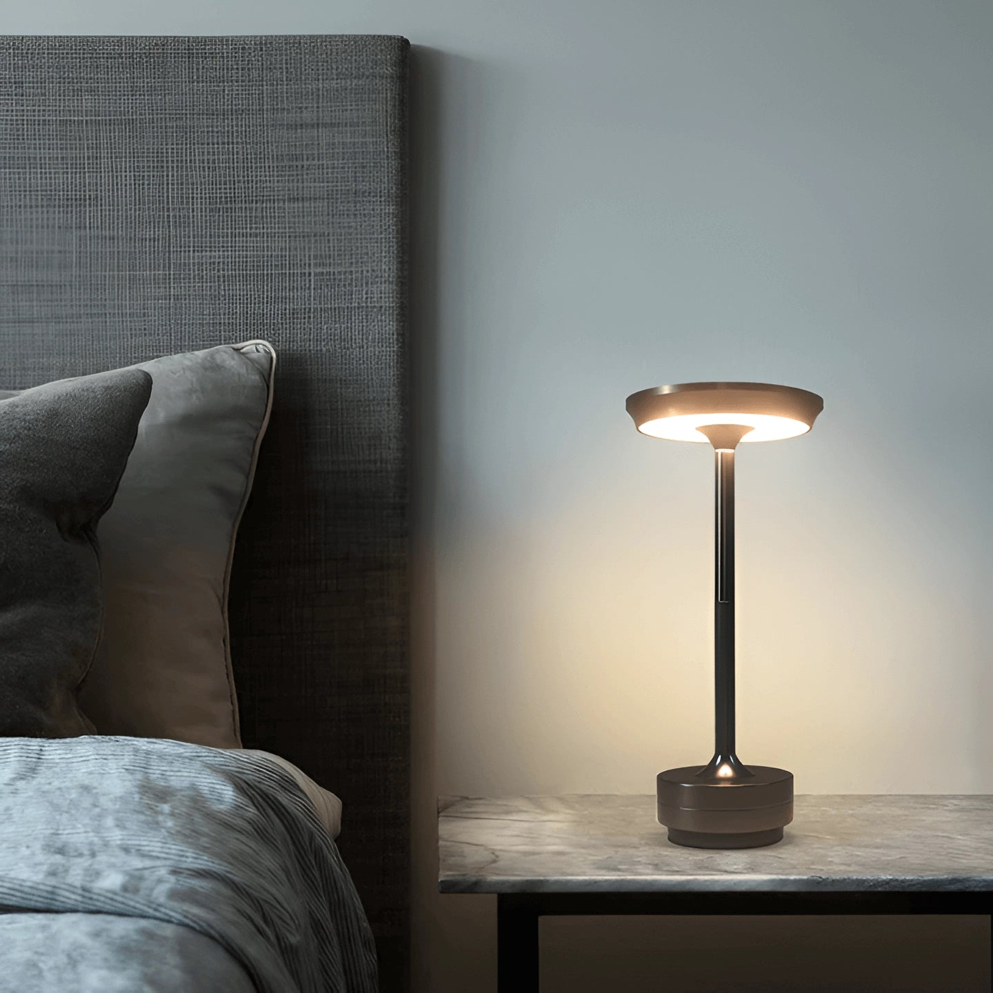 Rechargeable LED table lamp with a wooden base, featuring a rectangular shade, placed on a hardwood floor in a cozy, well-designed interior setting.