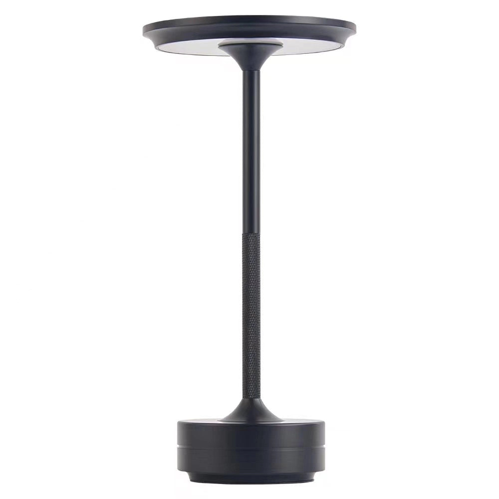 Rechargeable LED table lamp in black, cordless mood lighting, placed on a desk with modern home accessories.