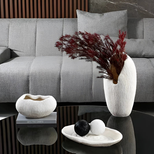 A resin nature-inspired decorative bowl placed on a wooden table in a modern living room setting with a white couch in the background.