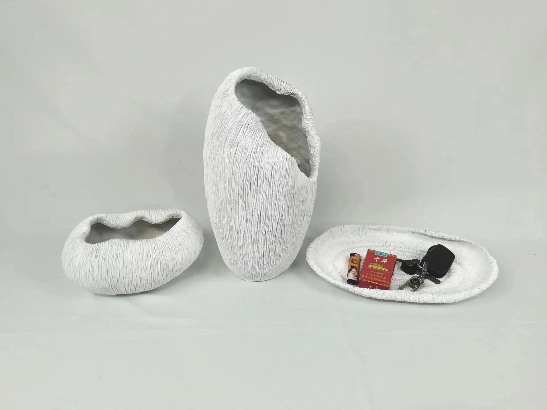 A grey, nature-inspired decorative bowl made of resin, featuring a wood-like texture and artistic design, placed on a rectangular surface.