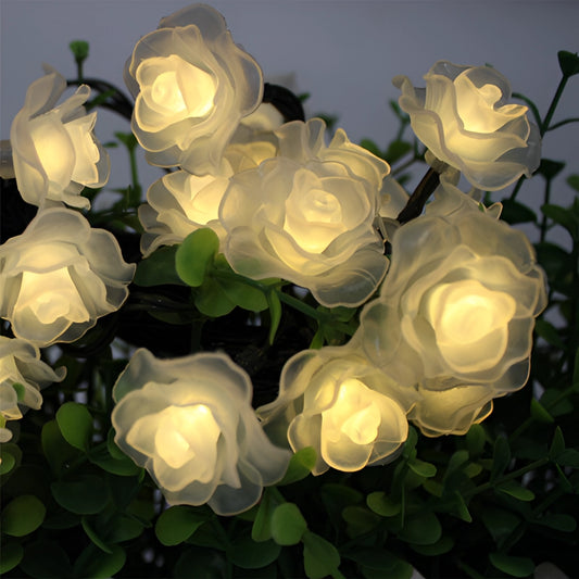 LED string lights featuring elegant rose-shaped flowers with green leaves, suitable for decorative purposes.