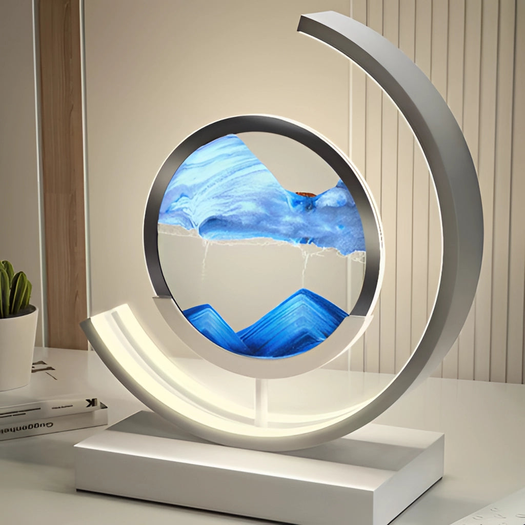 Sand Art LED Table Lamp featuring dynamic 3D sand painting light, placed on a table beside a houseplant in a flowerpot.