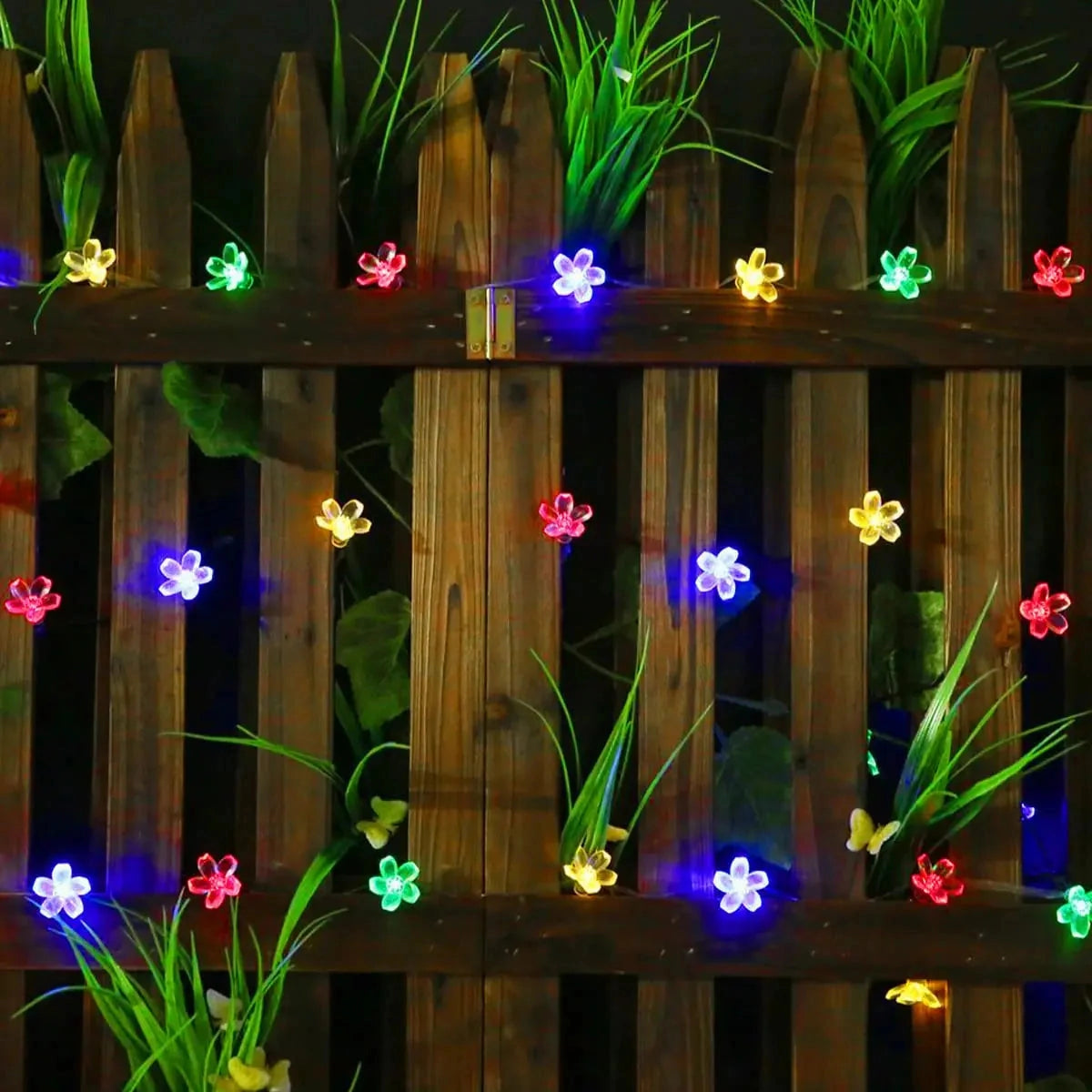 Solar Flower String Lights featuring Crystal Peach Blossom design, IP65 waterproof LED in RGB, Warm White, and Cold White, shown illuminating plants with vibrant colors including green and purple.