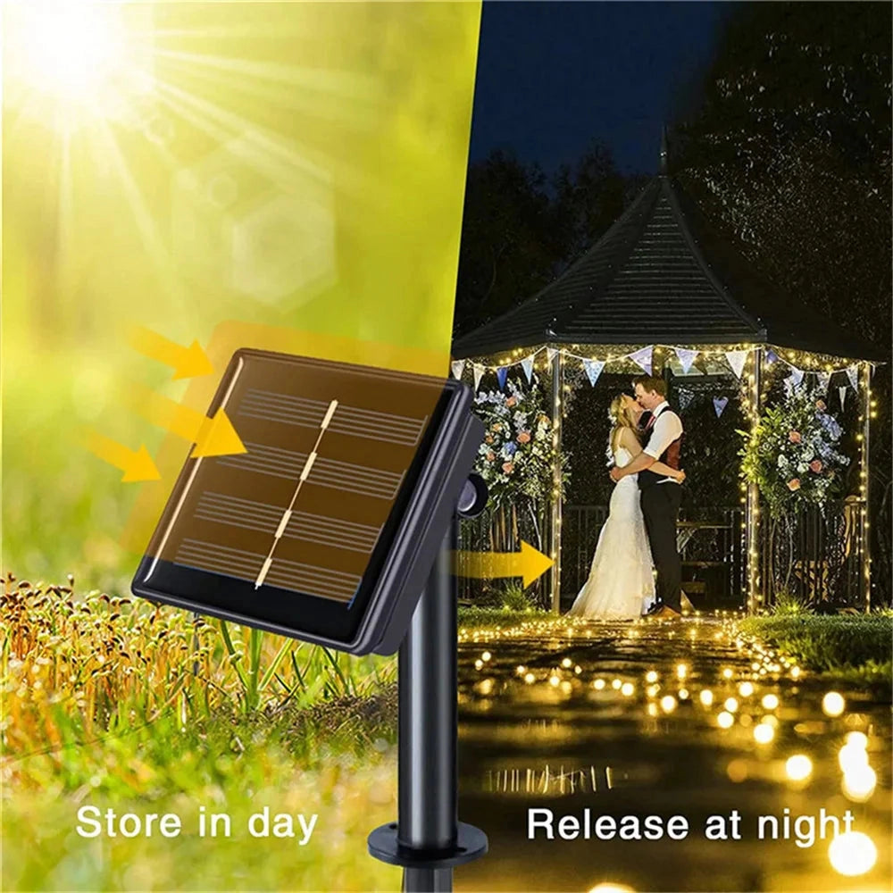 Outdoor setting featuring Solar String Light Curtain with RGB and white LED lights, IP65 waterproof, hanging among trees and plants, people in formal wear enjoying the illuminated natural landscape.