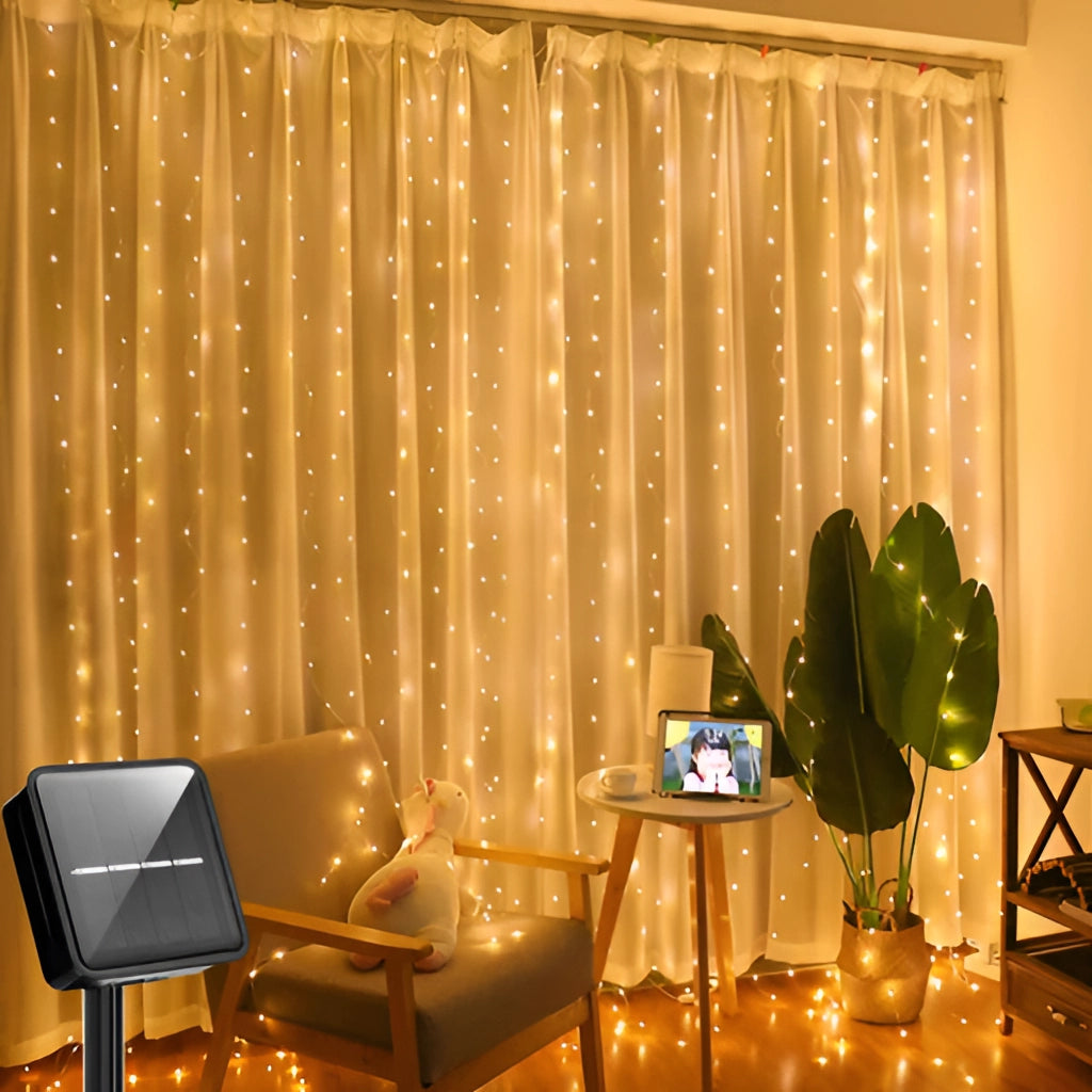 Outdoor LED solar string light curtain in warm white, 9ft x 9ft with 300 LEDs, IP65 waterproof, hanging and illuminating a cozy living room with furniture and plants.
