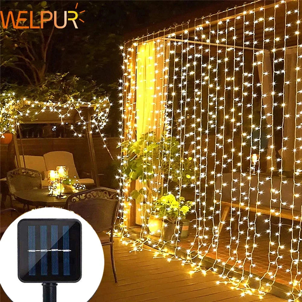 Outdoor solar string light curtain with RGB and white LED lights, IP65 waterproof rating, long battery life, hanging against a wall, illuminating plants and surroundings with festive, decorative lights.