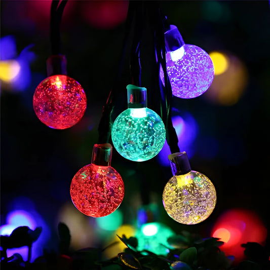 Solar string lights featuring IP65 waterproof RGB and white LEDs with long battery life, glowing in magenta and electric blue colors.