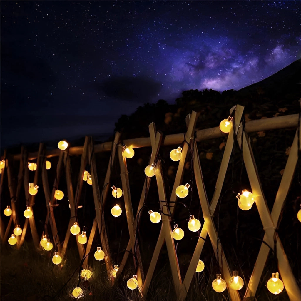 Solar string lights with IP65 waterproof RGB and white LEDs glowing brightly at night.