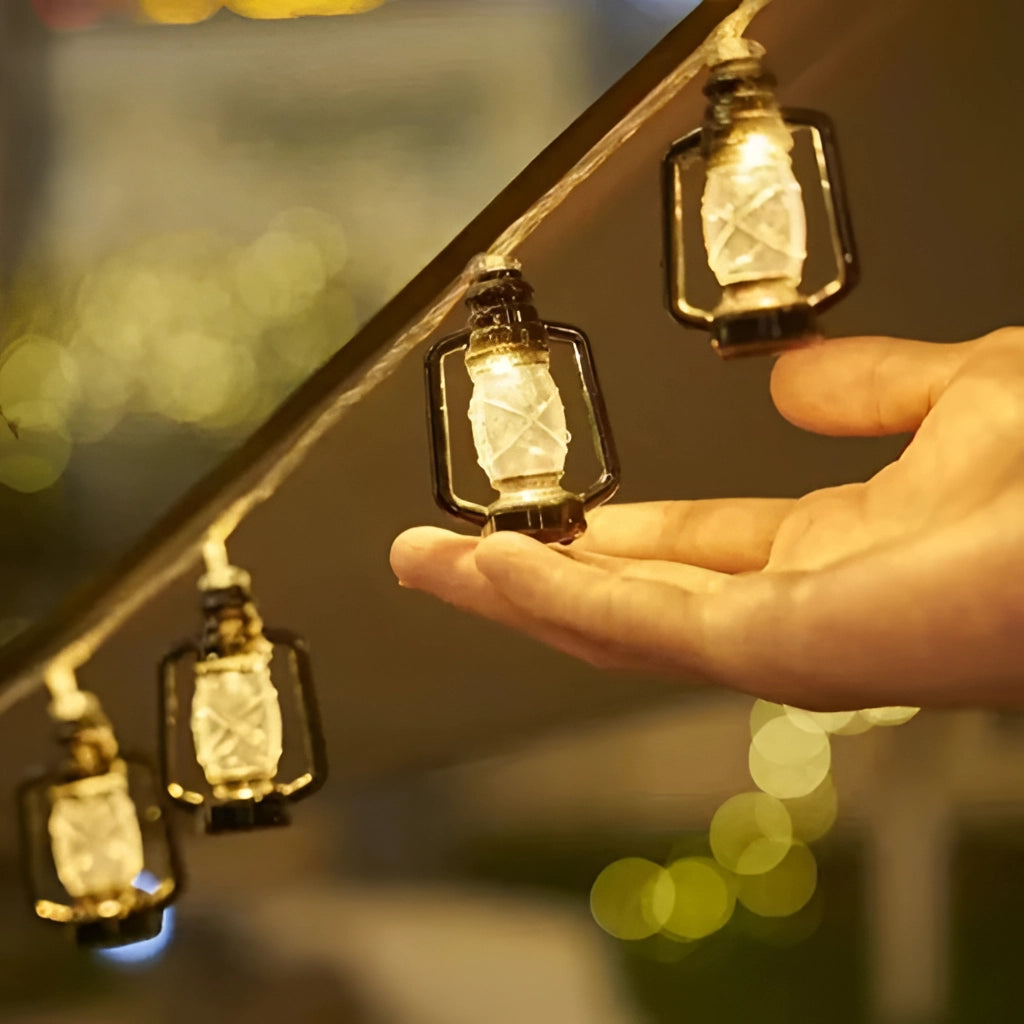 Outdoor solar string lights with LED lanterns in RGB and white colors, IP65 waterproof, glowing amber.