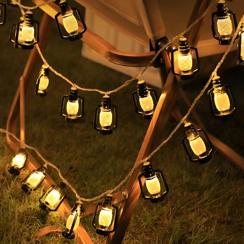 Solar string lights with RGB and white color lanterns, hanging outdoors, illuminated in the dark, demonstrating waterproof IP65 feature.
