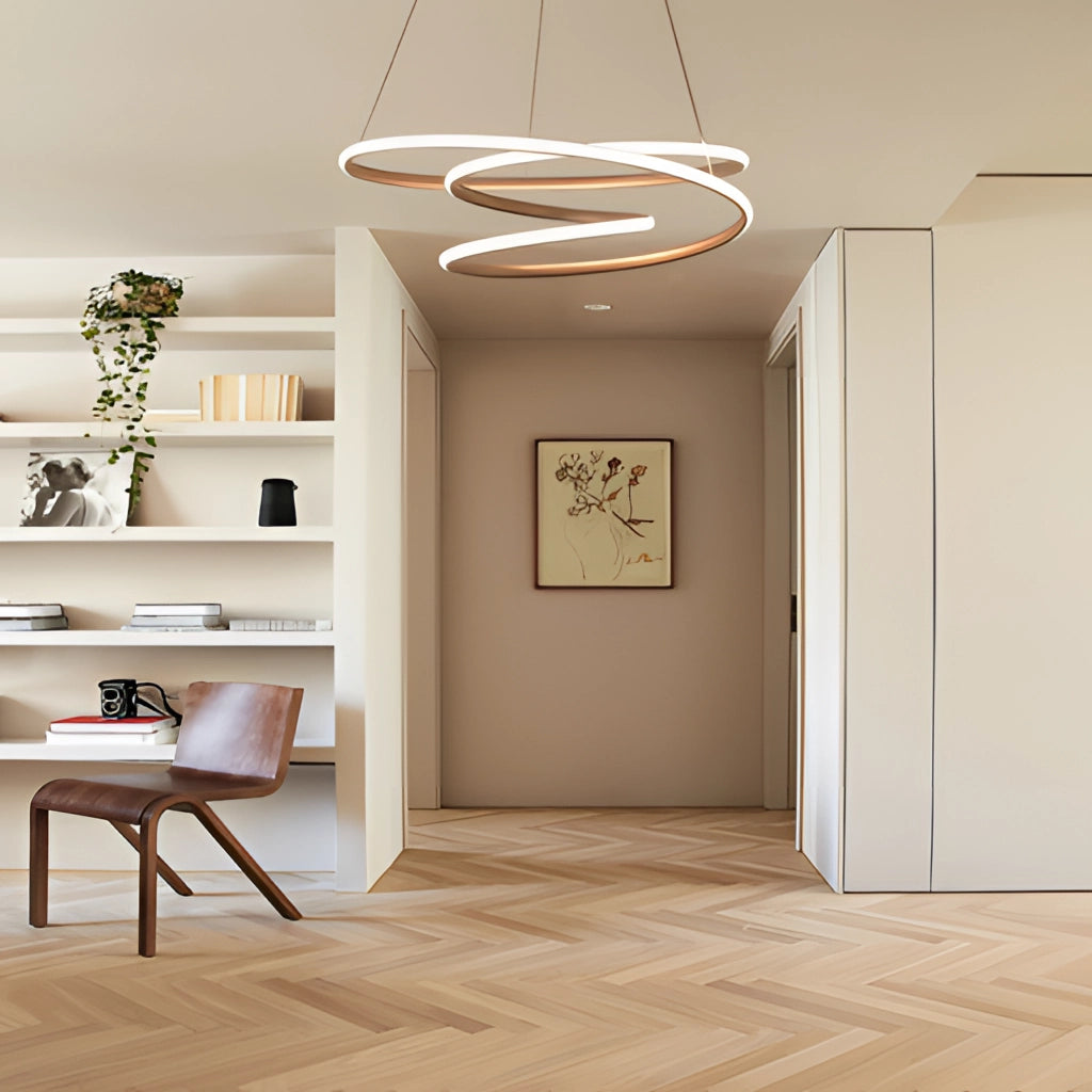 Modern spiral pendant light with warm illumination hanging over a wooden table in an elegant interior design setting.