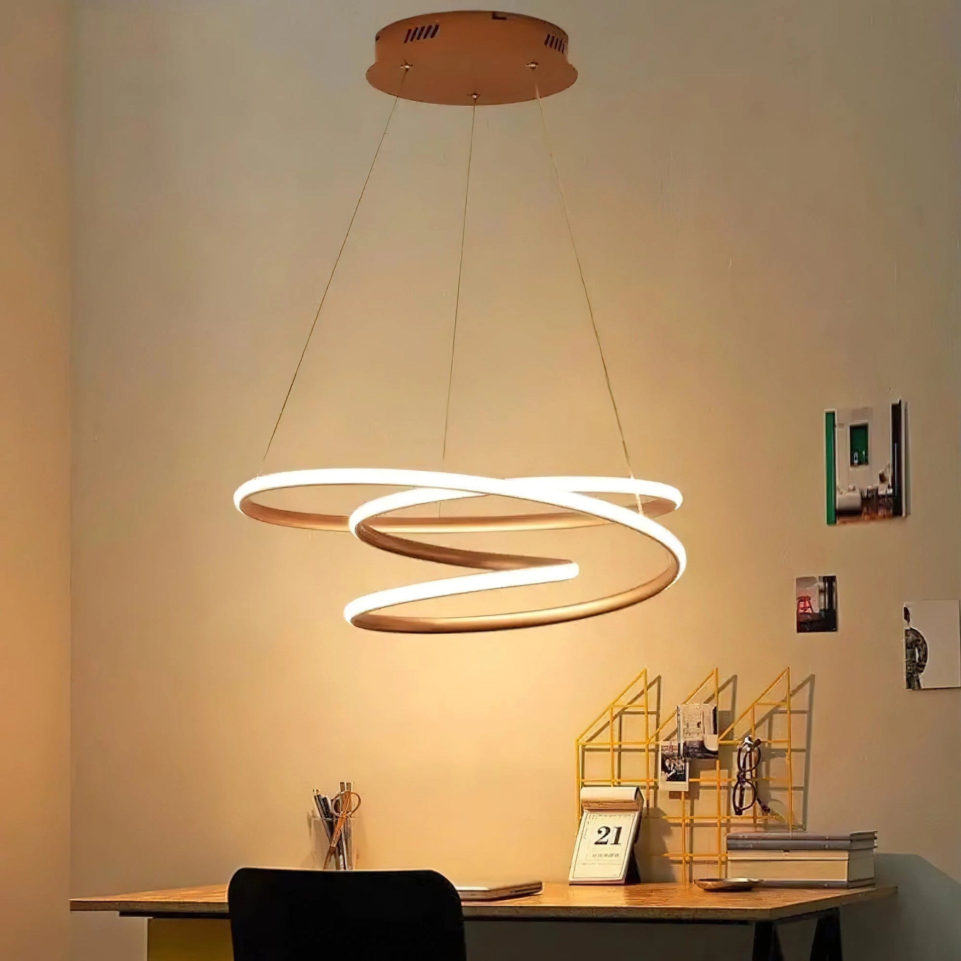 Elegant Spiral Pendant Light with warm illumination, modern aluminum design, hanging above a wooden table, enhancing interior design with amber tones and artistic appeal.