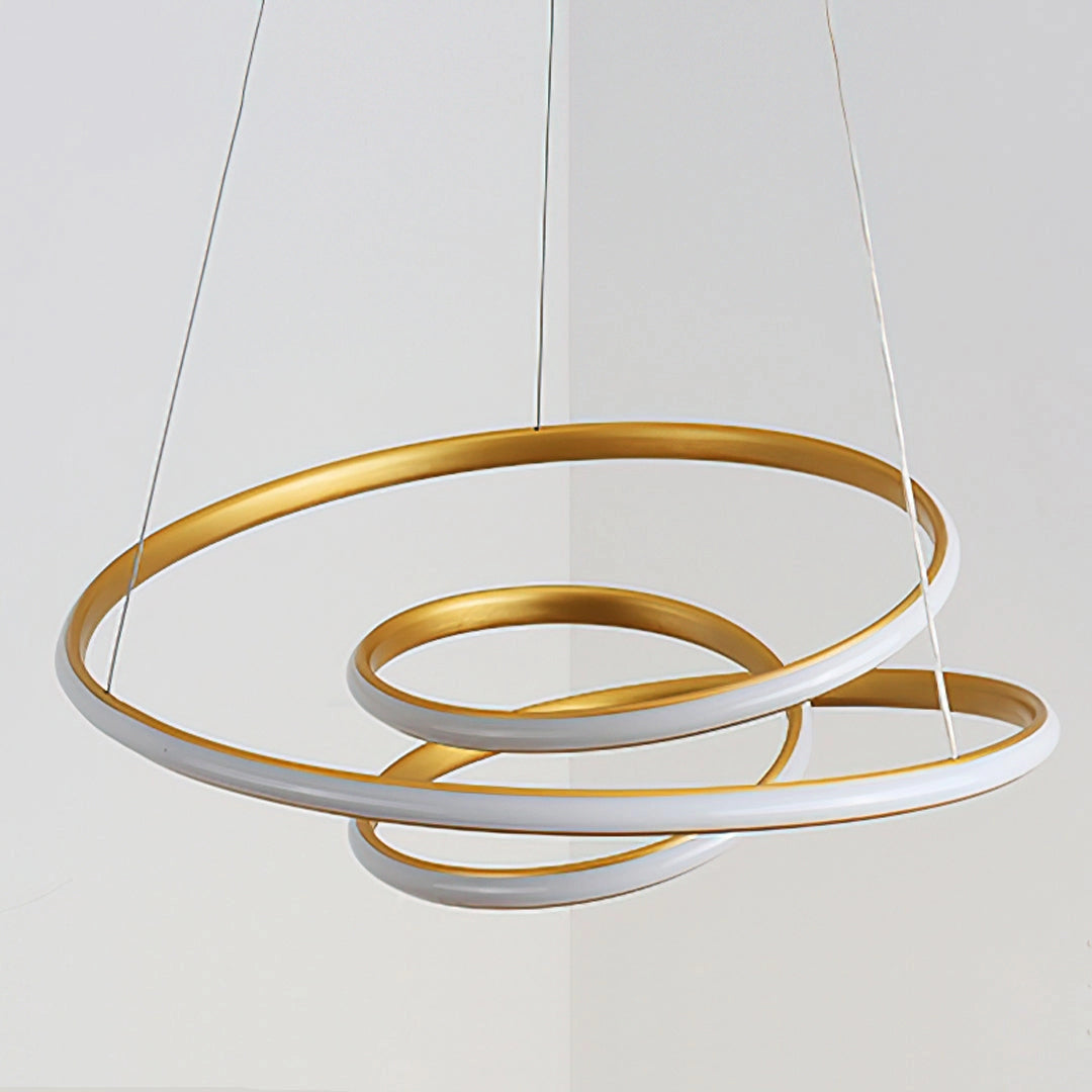 Elegant spiral pendant light in warm gold hue with an oval shape, made of aluminum, featuring a modern design, softly illuminating the space.