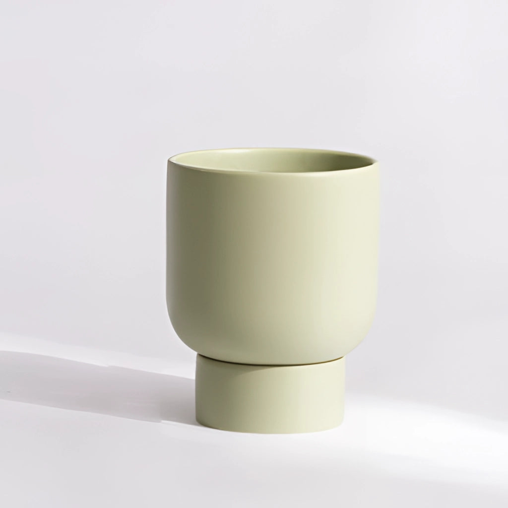 Pale green small ceramic flower pot with a stacked design, ideal for garden and bonsai arrangements, placed on a table.
