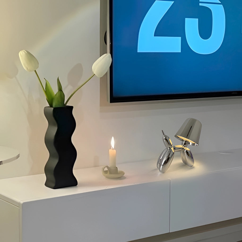 A white table lamp with a crystal base featuring a balloon dog design, touch-sensitive dimming control, and emitting a soft azure light.