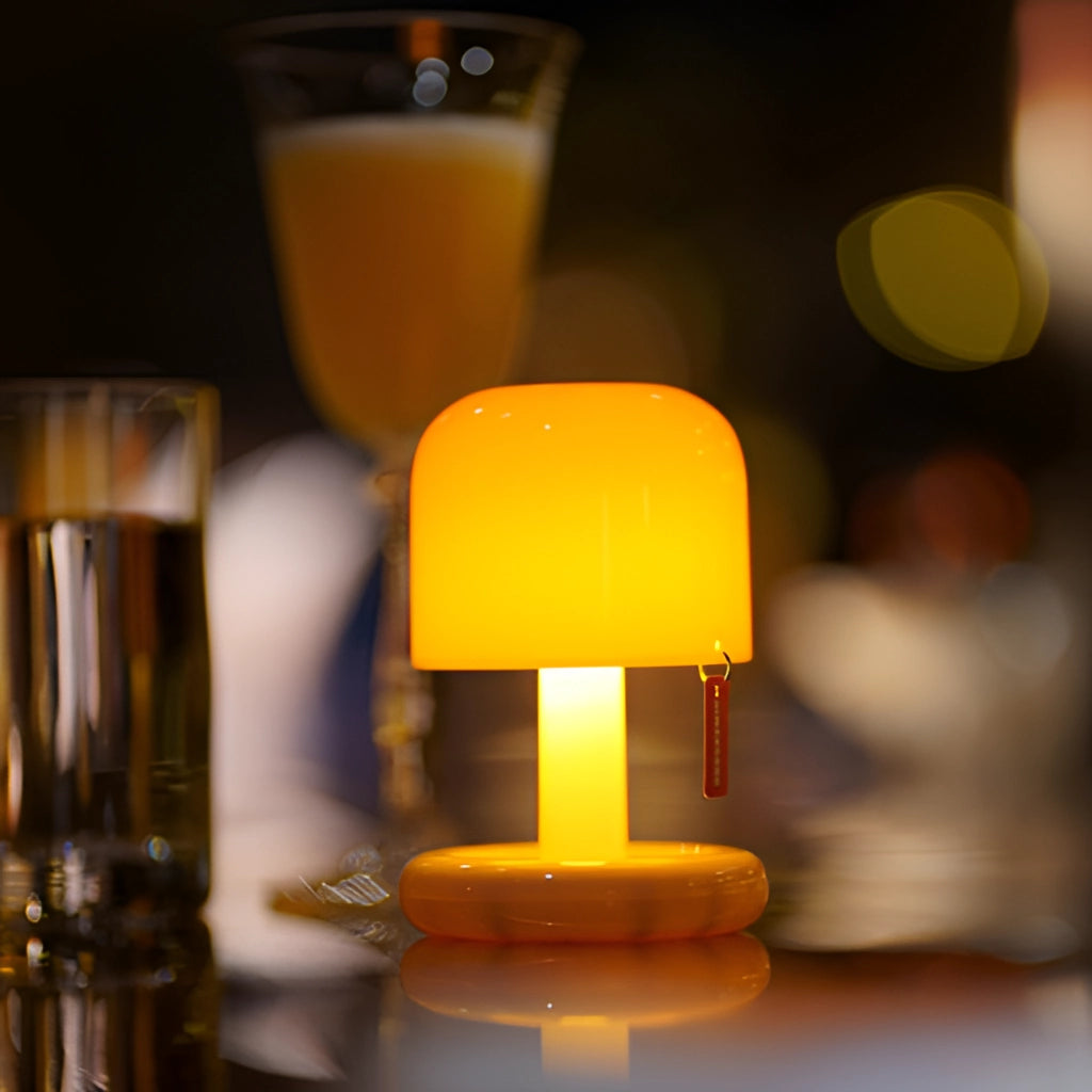 Ivory dimmable table lamp with touch switch placed on a surface next to a glass of orange juice.