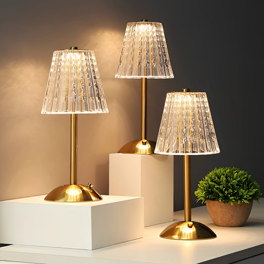 Table Lamp Tricolor Dimmable Cordless LED - Captivating View, illuminating a room with warm yellow light, placed on a wooden surface next to a green plant, showcasing modern interior design elements.