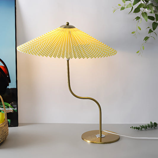 A table lamp with a yellow diamond-patterned shade, featuring a wooden base and an umbrella-like design, positioned next to a plant.