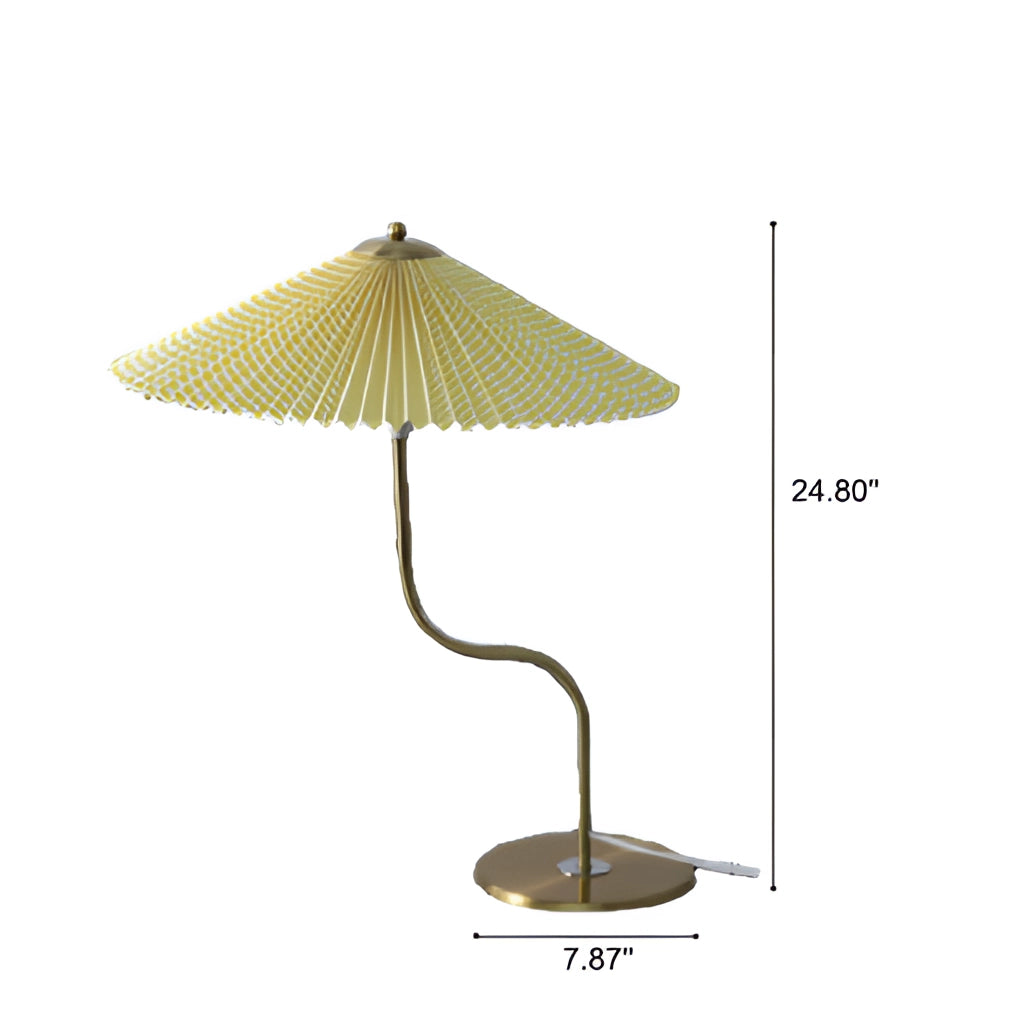 A table lamp with a yellow diamond-patterned umbrella shade, featuring khaki, white, and dark green floral designs, placed on a table next to a plant.