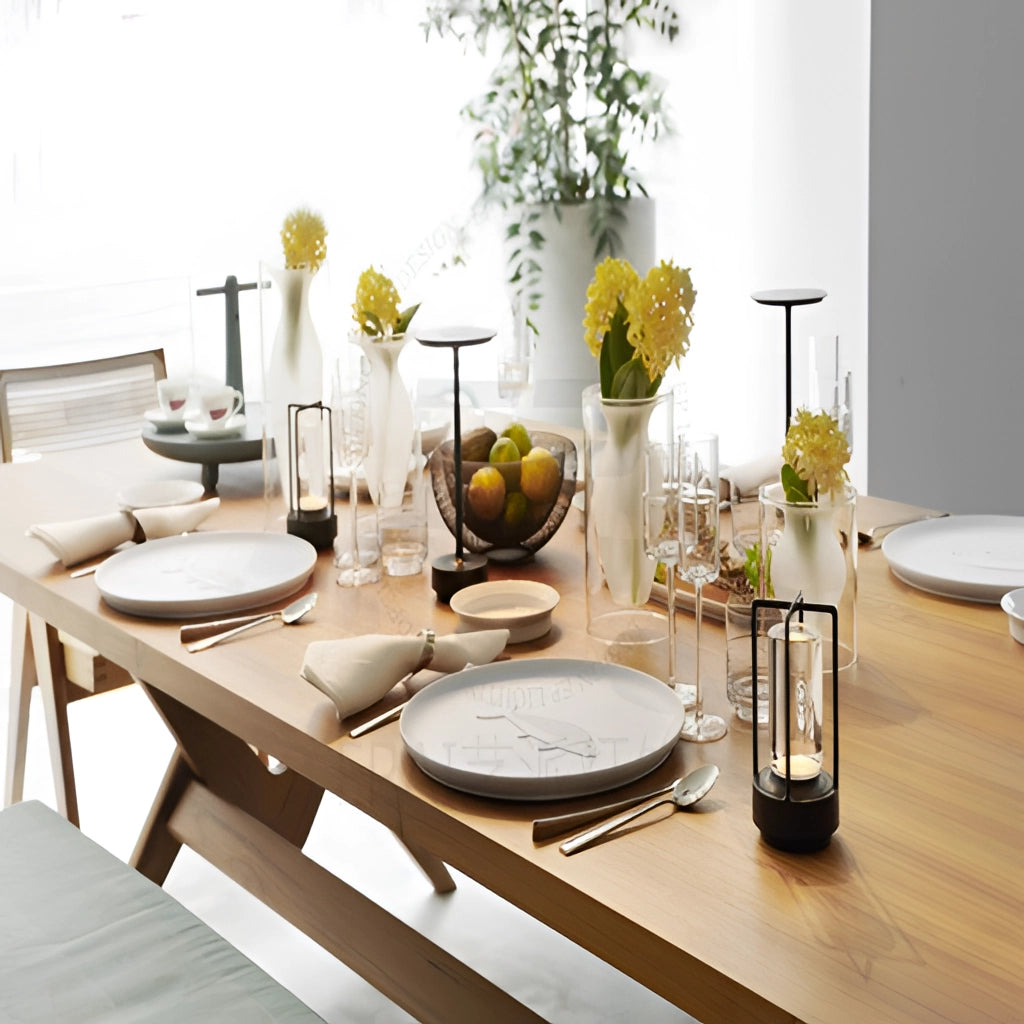 Table lamp with dimming feature placed on a table next to a potted plant, vase, picture frame, and dishware.